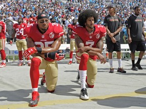 FILE - In this Sept. 18, 2016, file photo, San Francisco 49ers' Colin Kaepernick (7) and Eric Reid (35) kneel during the national anthem before an NFL football game against the Carolina Panthers, in Charlotte, N.C. Colin Kaepernick and Eric Reid have reached settlements on their collusion lawsuits against the NFL, the league said Friday, Feb. 19, 2019.