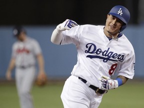 FILE - In this Oct. 5, 2018, file photo, then-Los Angeles Dodgers' Manny Machado celebrates his two-run home run against the Atlanta Braves during the first inning of Game 2 of a baseball National League Division Series, in Los Angeles. A person familiar with the negotiations tells The Associated Press that infielder Manny Machado has agreed to a $300 million, 10-year deal with the rebuilding San Diego Padres, the biggest contract ever for a free agent. The person spoke to the AP on condition of anonymity Tuesday, Feb. 19, 2019,  because the agreement was subject to a successful physical and had not been announced.