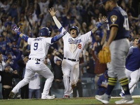 FILE - In this Oct. 16, 2018, file photo, Los Angeles Dodgers' Manny Machado (8) reacts after scoring on a Cody Bellinger walk-off hit during the 13th inning of Game 4 of the National League Championship Series baseball game against the Milwaukee Brewers, in Los Angeles. A person familiar with the negotiations tells The Associated Press that infielder Manny Machado has agreed to a $300 million, 10-year deal with the rebuilding San Diego Padres, the biggest contract ever for a free agent. The person spoke to the AP on condition of anonymity Tuesday, Feb. 19, 2019,  because the agreement was subject to a successful physical and had not been announced.