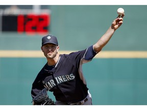 FILE - In this March 8, 2015, file photo, Seattle Mariners' J.A. Happ throws a pitch between innings as pitch clock counts down in the background during a spring training baseball game against the Cincinnati Reds in Goodyear, Ariz. Major League Baseball and its players are discussing bold changes to spark the sport that include a three-batter minimum before a pitching change except at the start of an inning, a single trade deadline set before the All-Star break and expanding rosters.