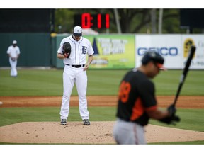 FILE - In this March 3, 2015, file photo, a clock counts down as Detroit Tigers pitcher Kyle Lobstein, left, prepares to deliver his first pitch of the second inning to Baltimore Orioles' Matt Tulasosopo during a spring training exhibition baseball game in Lakeland, Fla. A 20-second pitch clock will be phased in three stages during spring training, with the start of ball/strike penalties depending on negotiations with the players' association. Major League Baseball said Friday, Feb. 22, 2019, that the pitch clock will not be enforced this weekend and that beginning early next week umpires will issue reminders to batters and pitchers who violate the clock.