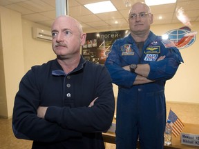 FILE - In this March 26, 2015 file photo, U.S. astronaut Scott Kelly, right, crew member of the mission to the International Space Station, stands behind glass in a quarantine room, behind his brother, Mark Kelly, also an astronaut, after a news conference in the Russian-leased Baikonur, Kazakhstan cosmodrome. Nearly a year in space put Scott Kelly's immune system on high alert and changed the activity of some of his genes compared to his Earth-bound identical twin, according to a report released on Friday, Feb. 15, 2019.