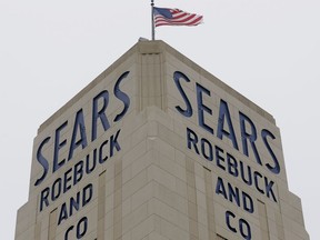 FILE- In this Jan. 8, 2019, file photo an American flag flies above a Sears store in Hackensack, N.J. A bankruptcy judge has blessed a $5.2 billion plan by Sears chairman and biggest shareholder Eddie Lampert to keep the iconic business going. The approval means roughly 425 stores and 45,000 jobs will be preserved.