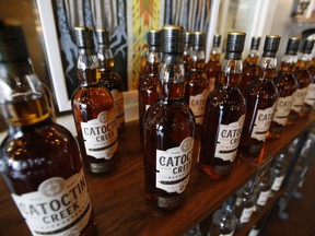 FILE - In this June 20, 2018 file photo, Catoctin Creek Distillery whiskey is on display in a tasting room in Purcellville, Va.  Retaliatory tariffs caused a sharp downturn in American whiskey exports in the last half of 2018 as distillers started feeling the pain from getting caught up in global trade disputes, an industry trade group said Tuesday, Feb. 12, 2019. Catoctin Creek Distillery has a couple hundred cases of its rye whiskey sitting in a European warehouse. The inventory was built up in anticipation of growing European sales in 2018. But since the tariffs took effect, their sales in Italy and Germany have plunged, and its plans of expanding to the United Kingdom are on hold, said its co-founder and general manager, Scott Harris.