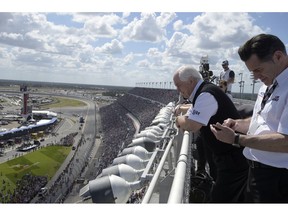 FILE - In this Feb. 22, 2015, file photo, team owner Roger Penske, second from right, watches from the roof of the front grandstands before the Daytona 500 NASCAR Cup Series auto race at Daytona International Speedway in Daytona Beach, Fla. Penske's drivers swept all the races at Indianapolis Motor Speedway and his reward has been induction into the NASCAR Hall of Fame. Penske will be honored Friday night along with Jeff Gordon, deceased drivers Davey Allison and Alan Kulwicki and fellow team owner Jack Roush.