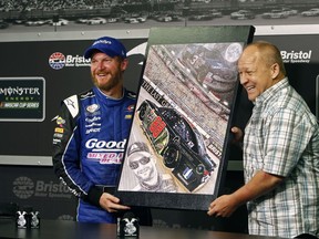 FILE - In this Aug. 17, 2017, file photo, NASCAR driver Dale Earnhardt Jr., left, stands with artist Sam Bass as he's presented with an original painting during a press conference at Bristol Motor Speedway in Bristol, Tenn. Bass, NASCAR's first officially licensed artist, has died following a battle with kidney problems. He was 57.