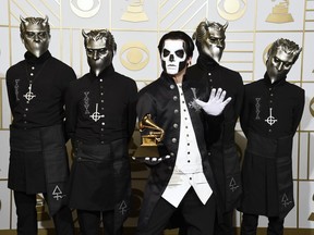 FILE - In this Feb. 15, 2016 file photo, Ghost poses in the press room with the award for best metal performance for "Cirice" at the 58th annual Grammy Awards in Los Angeles. Ghost is up for best rock album and best rock song at the Grammy Awards on Sunday.