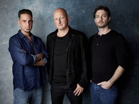 FILE - In this Jan. 24, 2019, file photo, Wade Robson, from left, director Dan Reed and James Safechuck pose for a portrait to promote the film "Leaving Neverland" during the Sundance Film Festival in Park City, Utah. The documentary, which premiered at the Sundance Film Festival to a standing ovation, will begin airing on HBO on Sunday.