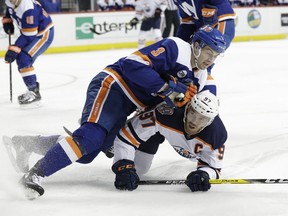 New York Islanders' Adam Pelech (3) knocks down Edmonton Oilers' Connor McDavid (97) during the first period of an NHL hockey game Saturday, Feb. 16, 2019, in Brooklyn.