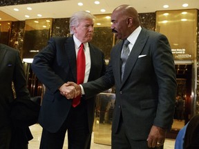 FILE - In this Jan. 13, 2017, file photo, President-elect Donald Trump shakes hands with comedian Steve Harvey in the lobby of Trump Tower in New York. The "black friend defense" played out before a national TV audience during this week's congressional testimony of Michael Cohen, President Donald Trump's former lawyer.