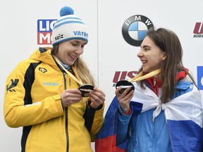 Gold medalists Jacqueline Loelling, left, of Germany, and Elena Nikitina, of Russia, compare their medals after tying for first place in the women's skeleton World Cup competition in Lake Placid, N.Y., Friday, Feb. 15, 2019.