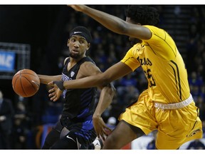 Buffalo guard CJ Massinburg (5) drives against Kent State forward Philip Whittington (25) during the first half of an NCAA college basketball game, Friday, Feb. 22, 2019, in Buffalo, N.Y.