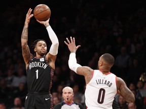 Brooklyn Nets guard D'Angelo Russell (1) shoots as Portland Trail Blazers guard Damian Lillard (0) defends during the first half of an NBA basketball game Thursday, Feb. 21, 2019, in New York.