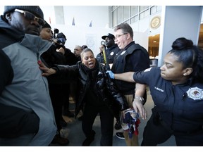 Corrections officers restrain a woman, center, who was among dozens of family members of prisoners and protesters objecting to conditions in the Metropolitan Detention Center, a federal prison in the Brooklyn borough of New York, Sunday, Feb. 3, 2019.