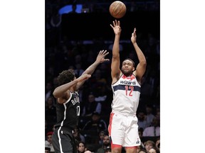 Washington Wizards forward Jabari Parker (12) shoots a three-pointer with Brooklyn Nets forward Ed Davis (17) defending during the first half of an NBA basketball game, Wednesday, Feb. 27, 2019, in New York.