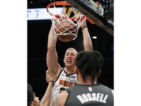 Denver Nuggets forward Mason Plumlee (24) dunks as Brooklyn Nets center Jarrett Allen, left, and Nets guard D'Angelo Russell watch during the first half of an NBA basketball game Wednesday, Feb. 6, 2019, in New York.