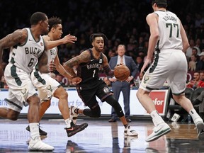 Brooklyn Nets guard D'Angelo Russell (1) drives past and Milwaukee Bucks guard Eric Bledsoe (6) Bucks guard Malcolm Brogdon (13) Bucks forward Ersan Ilyasova (77) defends during the first half of an NBA basketball game, Monday, Feb. 4, 2019, in New York.