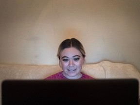 In this Jan. 14, 2019 photo, Caitlin Powers sits in the living room of her Brooklyn apartment in New York, and has a telemedicine video conference with physician, Dr. Deborah Mulligan. Widespread smartphone use, looser regulations and employer enthusiasm are helping to expand access to telemedicine, where patients interact with doctors and nurses from afar, often through a secure video connection.