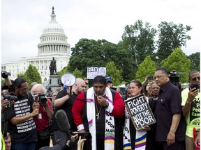 FILE - In this Saturday, June 23, 2018 file photo, Rev. Dr William Barber II accompanied by Rev. Dr. Liz Theoharis and Rev. Jesse Jackson speaks to the crowd outside of the U.S. Capitol during a Poor People's Campaign rally at The National Mall in Washington. The Rev. William Barber, a leader of the Poor People's Campaign says the social justice movement is planning bus tours of poverty-stricken areas in more than 20 states to refocus the country on its true emergencies.