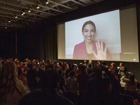 FILE - In this Sunday, Jan. 27, 2019 file photo, Rep. Alexandria Ocasio-Cortez, D-N.Y. waves as she appears on screen via video conference for a question and answer session after the premiere screening of the documentary "Knock Down the House" during the 2019 Sundance Film Festival in Park City, Utah. On Friday, Feb. 15, 2018, The Associated Press has found that stories circulating on the internet that the congresswoman received $10 million for the documentary, are untrue.