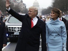 FILE- In this Jan. 20, 2017 file photo, President Donald Trump waves as he walks with first lady Melania Trump during the inauguration parade on Pennsylvania Avenue in Washington. A federal subpoena seeking documents from Donald Trump's inaugural committee is part of "a hysteria" over the fact that he's president, White House press secretary Sarah Sanders said on Tuesday, Feb. 5, 2019. Federal prosecutors in New York issued the subpoena on Monday, furthering a federal inquiry into a fund that has faced mounting scrutiny into how it raised and spent its money.