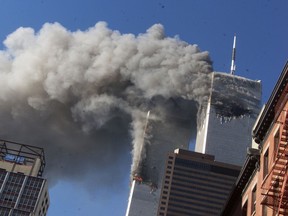 FILE - In this Sept. 11, 2001 file photo smoke rises from the burning twin towers of the World Trade Center after hijacked planes crashed into the towers, in New York City. On Friday, Feb. 15, 2019, Rupa Bhattacharyya, the September 11th Victim Compensation Fund special master, announced that the compensation fund for victims of the Sept. 11, 2001 terror attacks will cut future payments by 50 to 70 percent because the fund is running out of money.