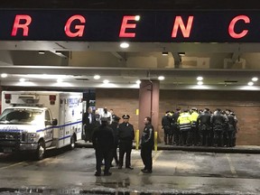 New York City police officers gather at Jamaica Hospital in the Queens borough of New York after a few NYPD officers while responding to a robbery in a mobile phone store on Tuesday, Feb. 12, 2019. One of them was killed Tuesday night while responding to a report of a gunpoint robbery at a cellphone store, an official briefed on the matter told The Associated Press. The official was not authorized to speak publicly and spoke on condition of anonymity.