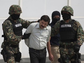 FILE - In this Saturday, Feb. 22, 2014 file photo, Joaquin "El Chapo" Guzman, center, is escorted to a helicopter in handcuffs by Mexican navy marines at a hanger in Mexico City, after he was captured overnight in the beach resort town of Mazatlan. The New York trial of Guzman is drawing to a close, but the question of controlling the corruption that allowed the Sinaloa cartel to flourish in Mexico will live on even after jurors reach a verdict. DEA agent Victor Vazquez told jurors he would only work with the Mexican marines when trying to capture Guzman and other leaders of the Sinaloa cartel, because that wing of the armed forced were viewed as less susceptible to corruption.