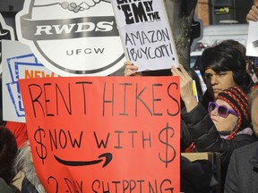 In this Nov. 14, 2018 file photo, protesters carry anti-Amazon signs during a coalition rally and press conference of elected officials, community organizations and unions opposing Amazon headquarters getting subsidies to locate in the New York neighborhood of Long Island City, the Queens borough of New York. Opposition to the retail giant coming to Long Island City by local politicians, some unions and residents of the community fearing the retail giant's presence will raise the cost of living was almost immediate.
