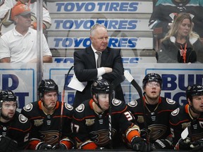 FILE - In a Wednesday, Jan. 23, 2019 file photo, Anaheim Ducks coach Randy Carlyle, center, watches during the third period of the team's NHL hockey game against the St. Louis Blues, in Anaheim, Calif. The Anaheim Ducks have fired coach Randy Carlyle amid a seven-game losing streak. The Ducks announced Sunday, Feb. 10, 2019  that general manager Bob Murray would take over as interim coach for the remainder of the regular season.