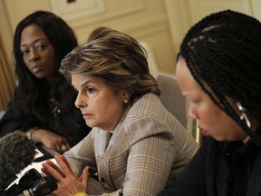 Attorney Gloria Allred, center, speaks while Latresa Scaff, right, and Rochelle Washington look on during a news conference in New York, Thursday, Feb. 21, 2019. Scaff and Washington are accusing musician R. Kelly of sexual misconduct on the night they attended his concert while they were teenagers.