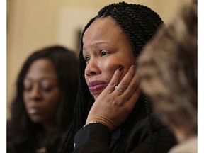 Rochelle Washington, left, and attorney Gloria Allred, right, look on Latresa Scaff speaks during a news conference in New York, Thursday, Feb. 21, 2019. Scaff and Washington are accusing musician R. Kelly of sexual misconduct on the night they attended  his concert when they were teenagers.