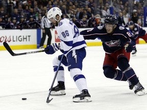 Tampa Bay Lightning forward Nikita Kucherov, left, of Russia, chases the puck against Columbus Blue Jackets defenseman Zach Werenski during the first period of an NHL hockey game in Columbus, Ohio, Monday, Feb. 18, 2019. Kucherov scored on the play.