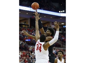 Rutgers forward Myles Johnson, center, goes up for a shot between Ohio State forward Kaleb Wesson, left, and forward Andre Wesson during the first half of an NCAA college basketball game in Columbus, Ohio, Saturday, Feb. 2, 2019.