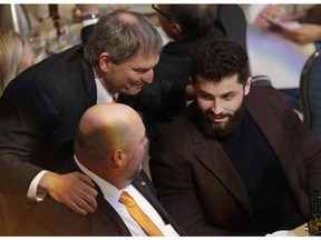 Former Cleveland Browns quarterback Bernie Kosar, top, talks with quarterback Baker Mayfield, right, and coach Freddie Kitchens at the Cleveland Sports Awards, Wednesday, Feb. 6, 2019, in Cleveland. Mayfield, who finished second to New York Giants running back Saquon Barkley for Offensive Rookie of the Year, is expected to win male athlete of the year at the Cleveland Sports Awards.