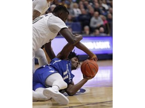 Buffalo's Jeenathan Williams (11) looks to pass against Akron's Deng Riak (10) in the first half of an NCAA college basketball game, Tuesday, Feb. 12, 2019, in Akron, Ohio.