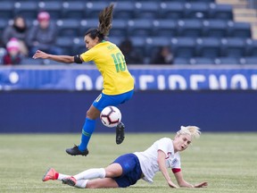 Brazil's Marta, left, leaps over England's Steph Houghton, right, as the ball gets kicked away during the first half of the SheBelieves Cup soccer match, Wednesday, Feb. 27, 2019, in Chester, Pa.
