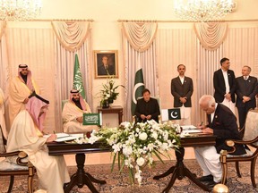 In this handout photograph taken and released by Pakistan's Press Information Department (PID) on February 17, 2019, Pakistan's Prime Minister Imran Khan (C-R) and Saudi Arabian Crown Prince Mohammed bin Salman (4L) look at their delegation members during a signing of a memorandum of understanding (MOU) at The Prime Minister House in Islamabad.