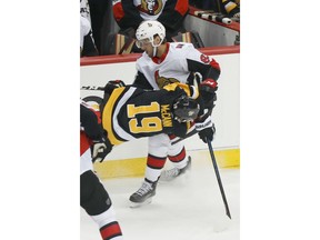 Newly acquired Pittsburgh Penguins' Jared McCann (19) is toppled as he is checked by Ottawa Senators' Christian Jaros during the first period of an NHL hockey game, Friday, Feb. 1, 2019, in Pittsburgh.