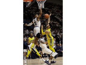Marquette's Markus Howard, right, cannot get a shot past Villanova's Phil Booth, left, and Saddiq Bey during the first half of an NCAA college basketball game, Wednesday, Feb. 27, 2019, in Villanova, Pa.
