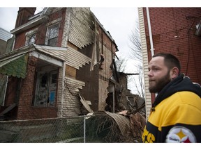 Longtime Hazelwood resident Chris Crist stands in his yard observing the condemned home next door that collapsed due to strong winds Sunday, Feb. 24, 2019, along 2nd Ave. in Hazelwood neighborhood of Pittsburgh. The only current damage to Crist's home, due to the collapse, is to the fence separating the houses.