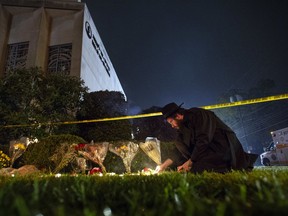 FILE - In this Oct. 27, 2018 photo, Rabbi Eli Wilansky lights a candle after a mass shooting at Tree of Life Synagogue in Pittsburgh's Squirrel Hill neighborhood. Robert Bowers, a truck driver accused of killing 11 and wounding seven during an attack on the Pittsburgh synagogue in October is expected to appear Monday, Feb. 11, 2019, morning in a federal courtroom to be arraigned on additional charges.
