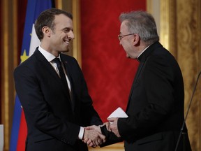 FILE - In this Jan.4, 2018 file photo, French President Emmanuel Macron greets Apostolic Nuncio to France Luigi Ventura during his New Year address to diplomats at the Elysee Palace in Paris. The Paris prosecutor's office has opened an investigation into alleged "sexual aggression" by Luigi Ventura, the Vatican's envoy to France, according to a French judicial official.