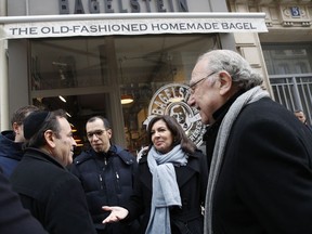 Paris mayor Anne Hidalgo, second right, talks with the President of the Central Jewish Consistory of Paris Joel Mergui, left, as district mayor Pierre Aidenbaum, right, looks on outside the bagel shop which was sprayed with the German word "Juden" on its front window last week, in Paris, Tuesday, Feb.12, 2019. According to French authorities, the total of registered anti-Semitic acts rose to 541 in 2018 from 311 in 2017, a rise of 74 percent.