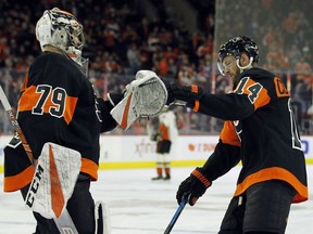 Philadelphia Flyers' Carter Hart, left, congratulates Sean Couturier on his goal during the first period of an NHL hockey game against the Anaheim Ducks, Saturday, Feb. 9, 2019, in Philadelphia.