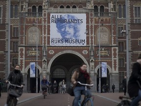 Bicyclists pass through an underpass of the Rijksmuseum where a billboard reads "All Rembrandts" to draw attention to an exhibition of the all the Rijksmuseum's Rembrandts in Amsterdam, Netherlands, Wednesday, Feb. 13, 2019. To mark the 350th anniversary of the Dutch master's death, museums across the Netherlands have declared 2019 Rembrandt and the Golden Age Year and are staging a string of exhibitions to highlight their collections.