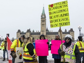 Pro-pipeline supporters arrived in a convoy from Alberta and other parts of the country for the second day to protest against the Liberal government on Parliament Hill in Ottawa on Wednesday Feb 20, 2019. Pro-pipeline supporters, in yellow vests, talk to two anti-racist protestors in front of Parliament Hill.