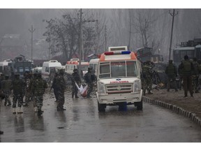 In this Feb. 14, 2019 photo, Indian paramilitary soldiers carry the remains of colleagues at the site of an explosion that killed at least 40 soldiers in Pampore, Indian-controlled Kashmir.