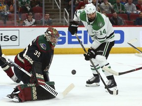 Arizona Coyotes goaltender Darcy Kuemper (35) makes a save on a shot as Dallas Stars left wing Jamie Benn (14) looks for a possible rebound during the first period of an NHL hockey game Saturday, Feb. 9, 2019, in Glendale, Ariz.