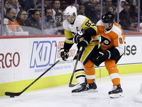 Pittsburgh Penguins' Sidney Crosby (87) and Philadelphia Flyers' Travis Sanheim (6) battle for the puck during the first period of an NHL hockey game, Monday, Feb. 11, 2019, in Philadelphia.